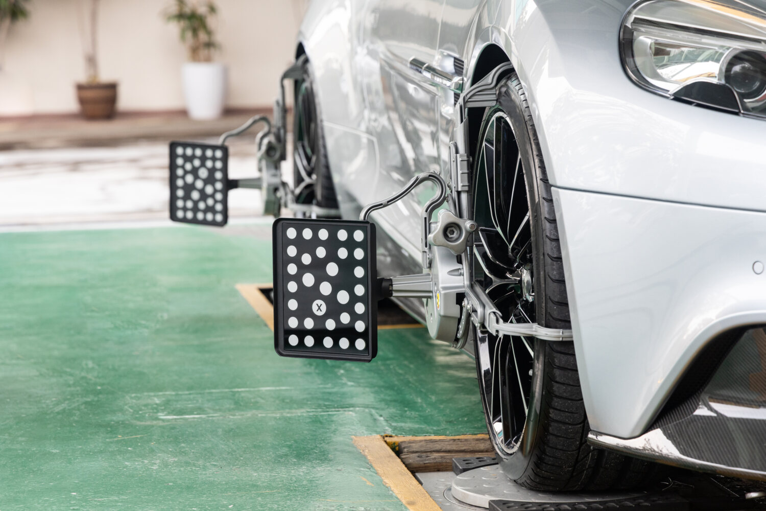 Technician calibrating a vehicle on an alignment rack after accident repairs