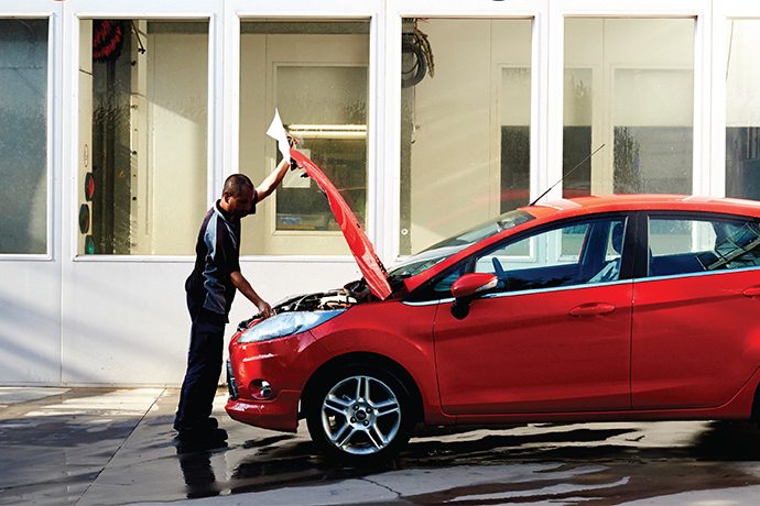 Capital SMART technician inspecting a vehicle with the bonnet raised